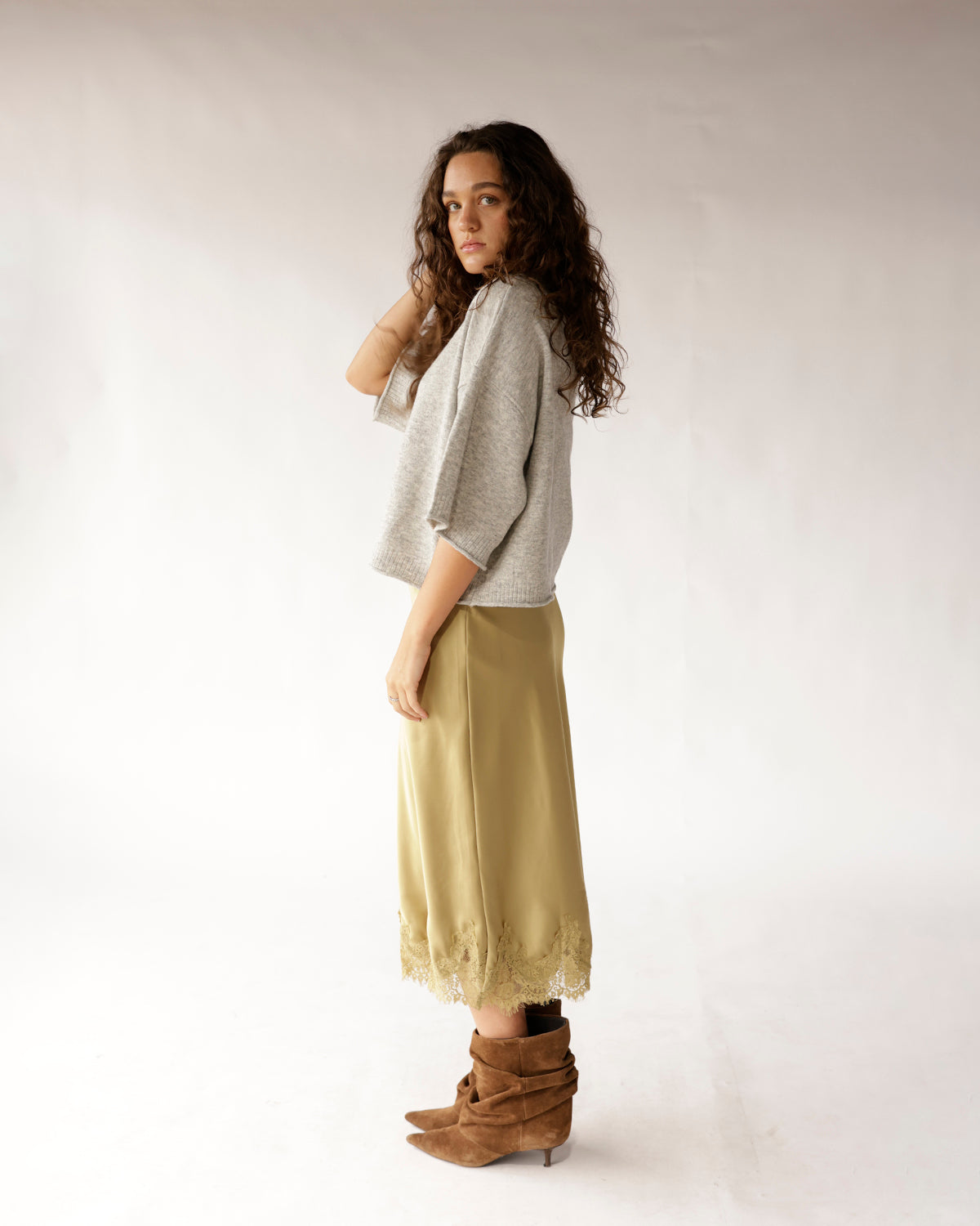 Light gray knit sweater with three-quarter sleeves, worn with olive midi skirt