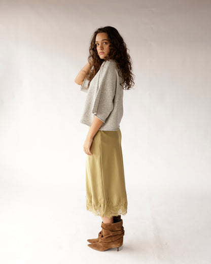Light gray knit sweater with three-quarter sleeves, worn with olive midi skirt