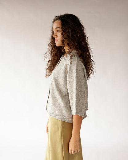 Gray heathered short-sleeve knit sweater with ribbed hem, side profile view