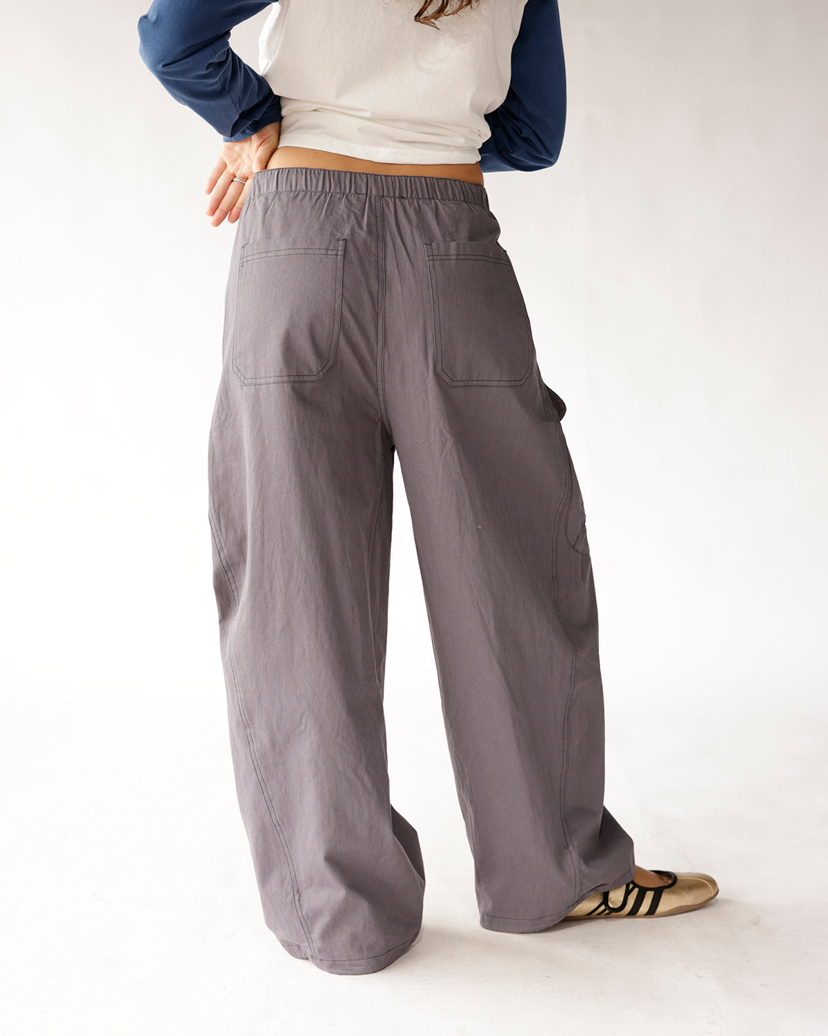 Gray wide-leg cargo pants with elastic waist and back patch pockets, rear view