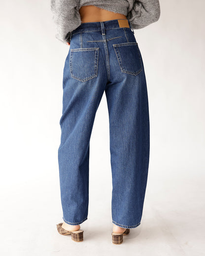 Back view of dark blue relaxed barrel jeans with two back pockets