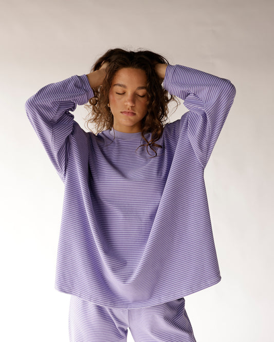 Stay comfortable in style with this lilac/lavender] striped oversized top featuring a relaxed fit, dropped shoulders, curved hem, and classic crew neckline. The perfect everyday top for denim, leggings, or biker shorts.