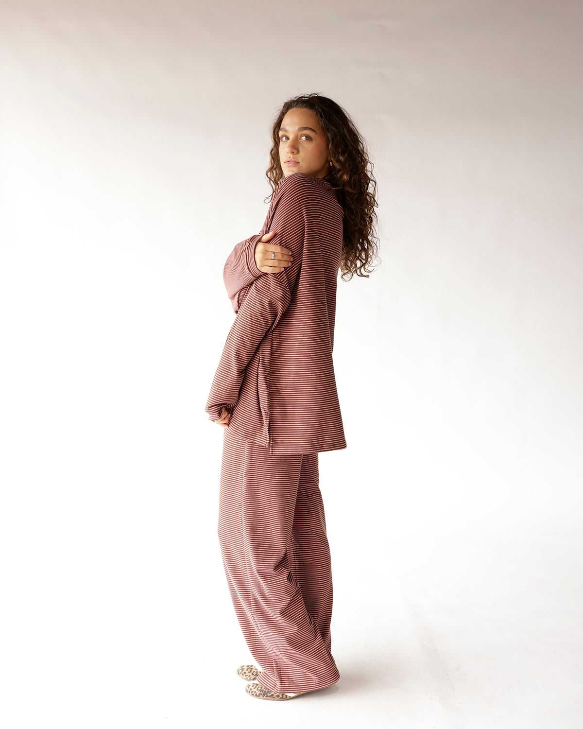 Striped burgundy and pink long sleeve top with wide-leg matching pants, side view