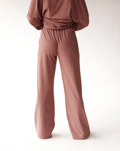 Rust red and white striped wide-leg lounge pants with elastic waistband, back view.