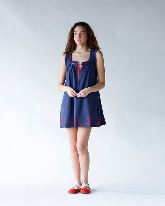 navy blue mini dress with embroidered nautical design at hem