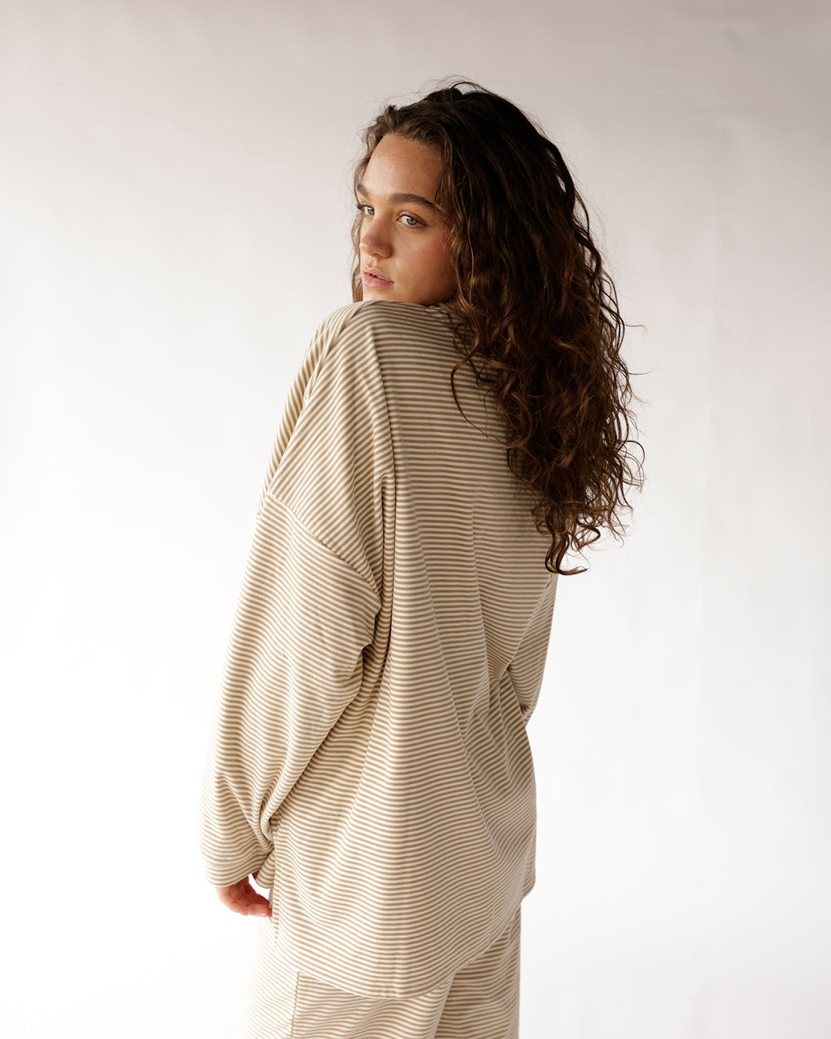Oversized striped long sleeve top in oatmeal and cream, worn from behind
