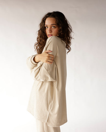 Oatmeal striped long sleeve top, relaxed fit, worn by model hugging arms