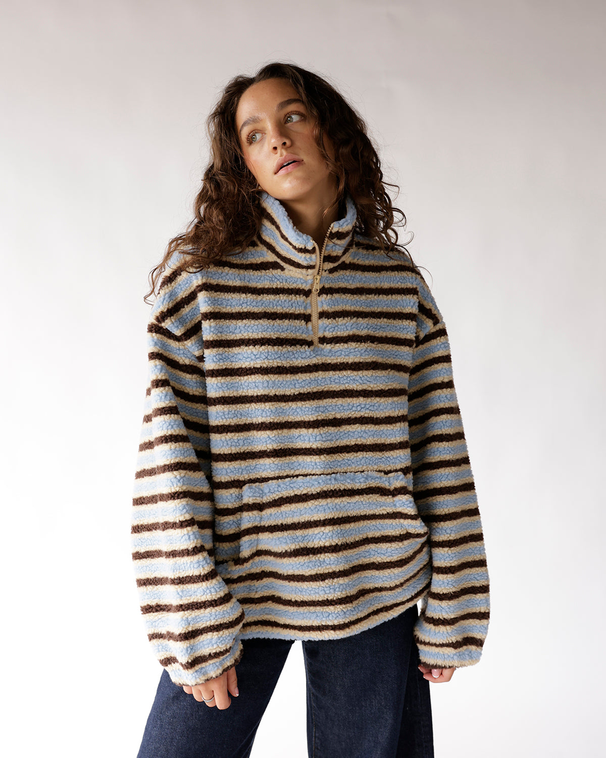 Striped sherpa quarter-zip pullover in blue, beige, and brown on a model
