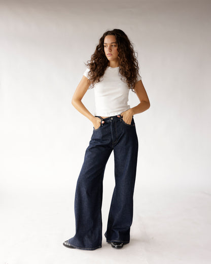Dark wash wide-leg jeans paired with a white fitted t-shirt and black shoes.