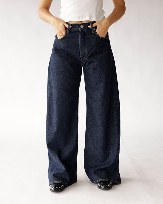 Dark wash wide-leg jeans with high waist, button closure, and contrast stitching