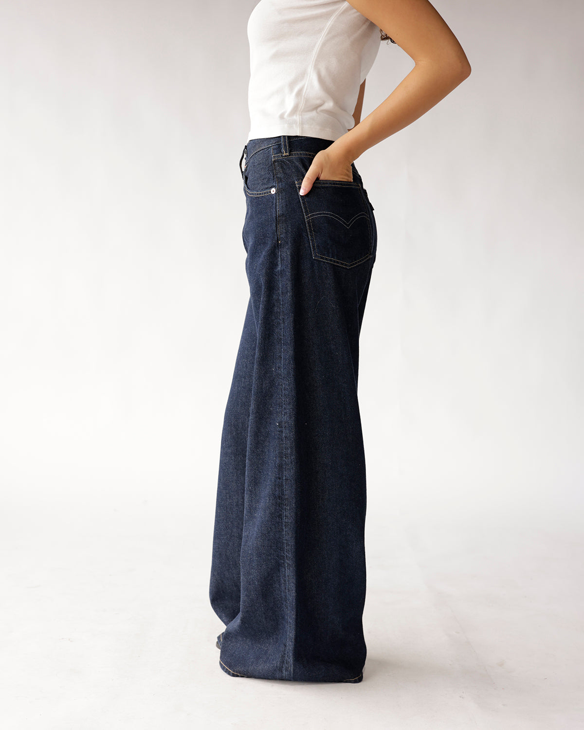Dark wash wide-leg flare jeans with contrast stitching, worn with white top