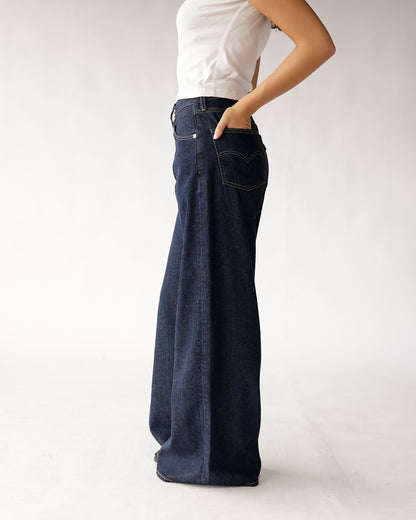 Dark wash wide-leg flare jeans with contrast stitching, worn with white top