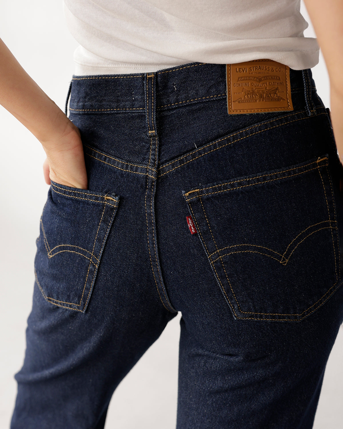Dark indigo loose boot jeans, back view, gold stitching, patch label, red tab