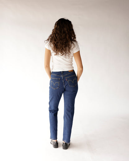 Dark blue straight-leg denim jeans worn with white fitted tee, back view