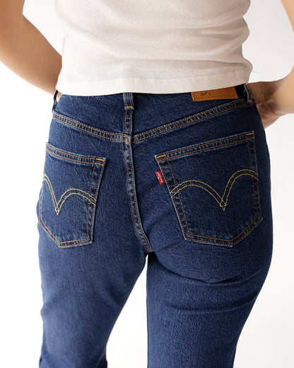 Back view of dark blue denim jeans with gold stitching and double back pockets