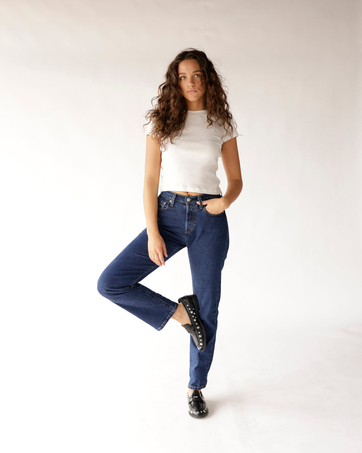 Dark blue high-rise straight-leg jeans worn with white crop tee and black loafers