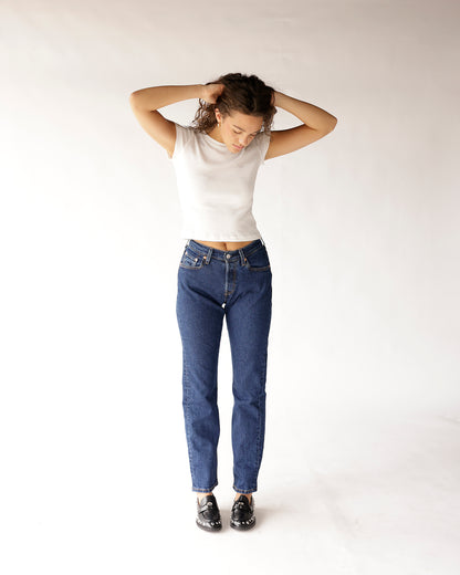 Dark blue straight-leg jeans with classic five-pocket styling, worn with white crop top