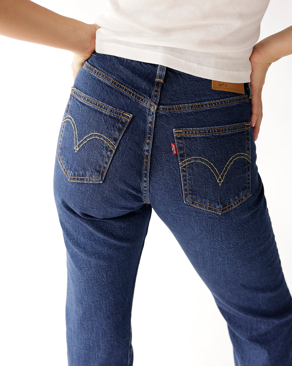 Dark blue straight-leg jeans back view with gold stitching and rear pockets