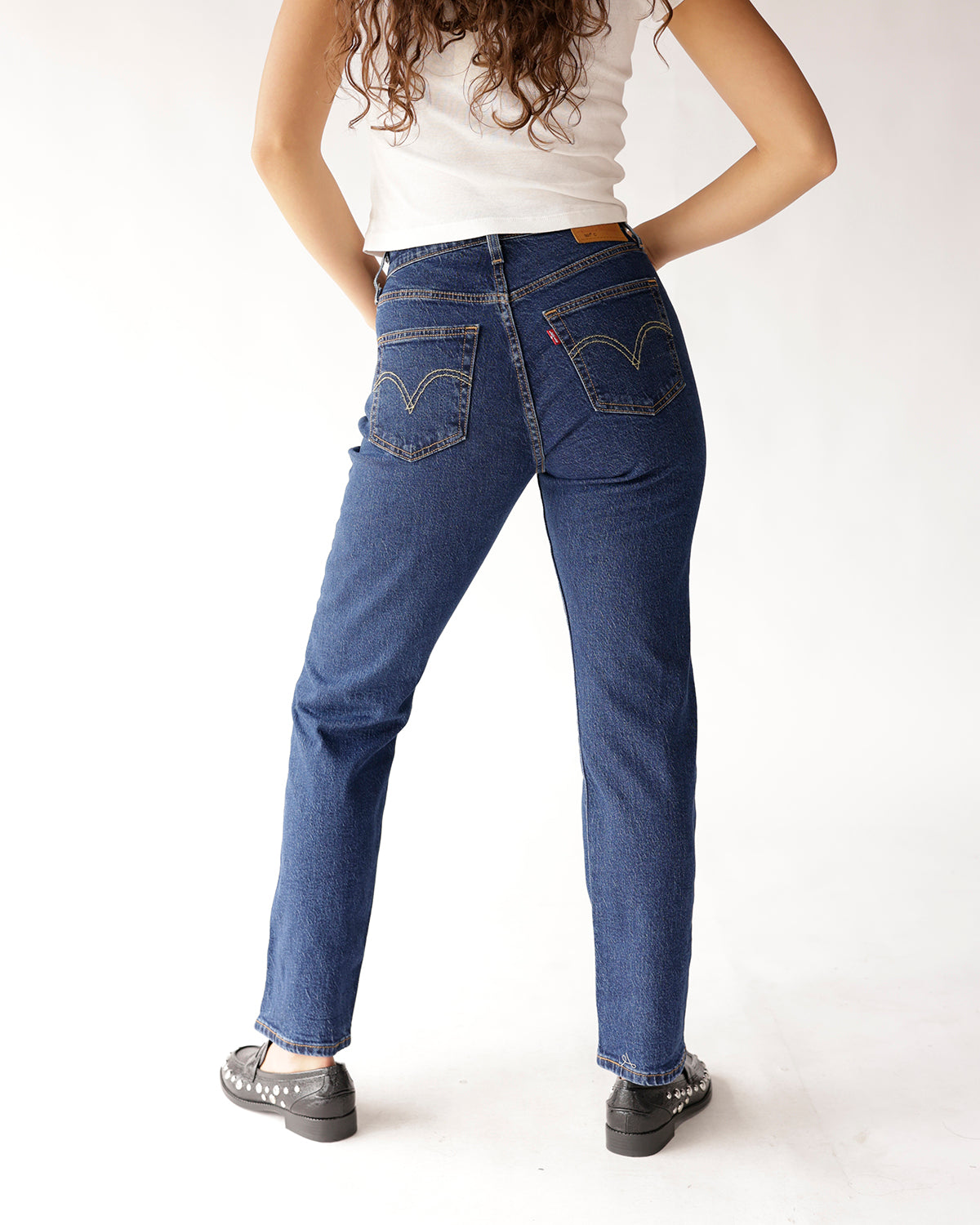 Dark blue straight-leg high-rise jeans with gold stitching, back view