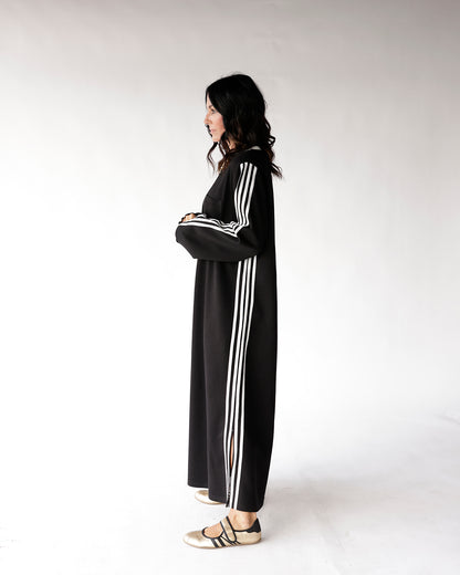 Black maxi track dress with white three stripes, long sleeves, side slit