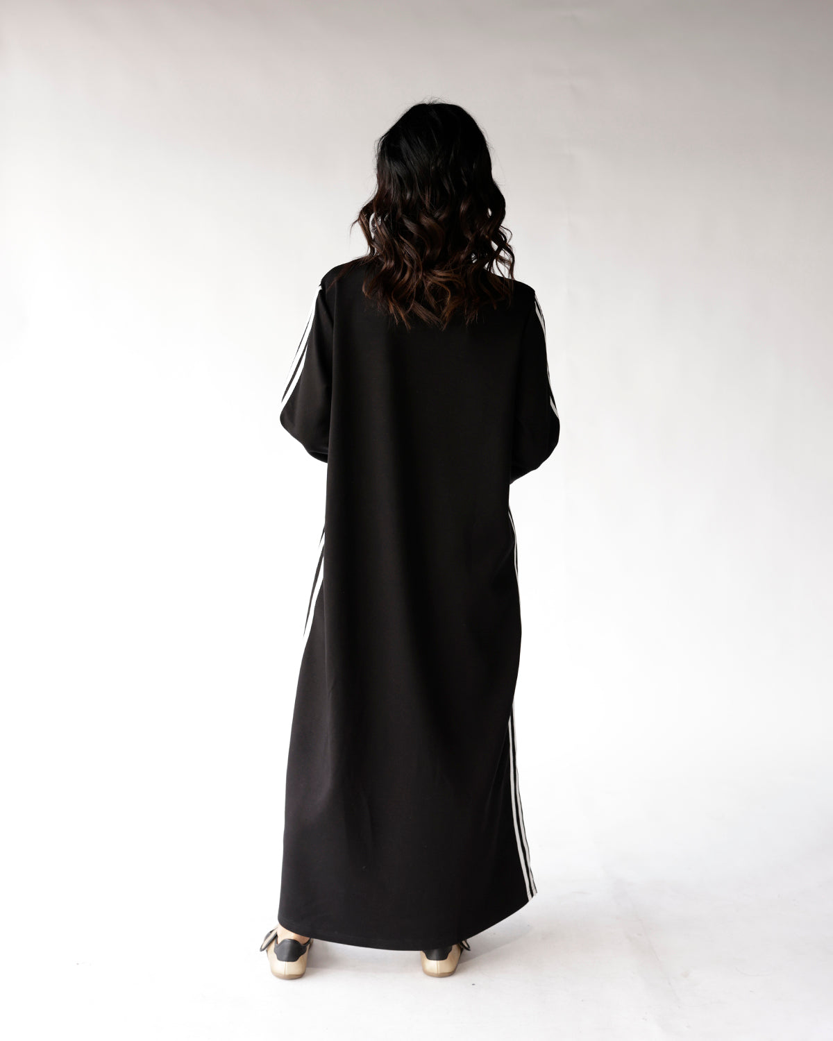 Black maxi dress with white side stripes and long sleeves, back view