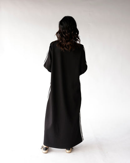 Black maxi dress with white side stripes and long sleeves, back view
