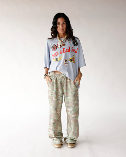 Oversized wide-leg camo sweatpants in soft green, tan, and pink tones with drawstring waist