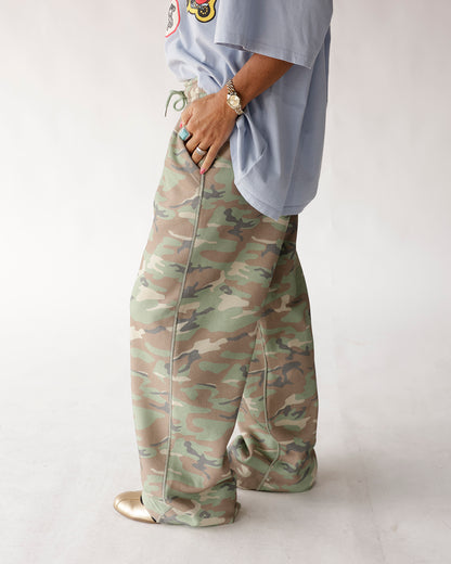 Oversized wide-leg camo sweatpants in green and tan with drawstring waist