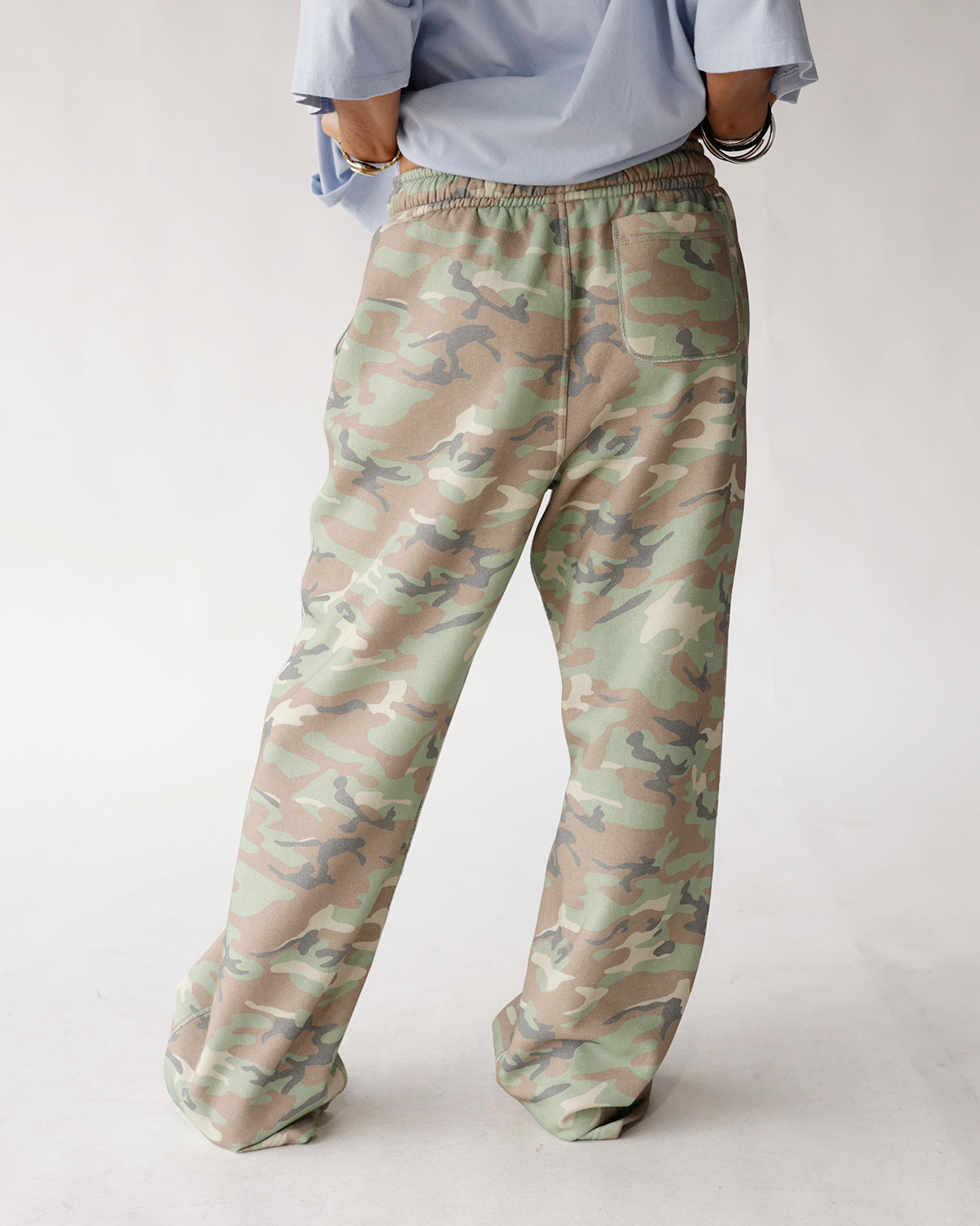Oversized wide-leg camo sweatpants in green, tan, and gray with elastic waist