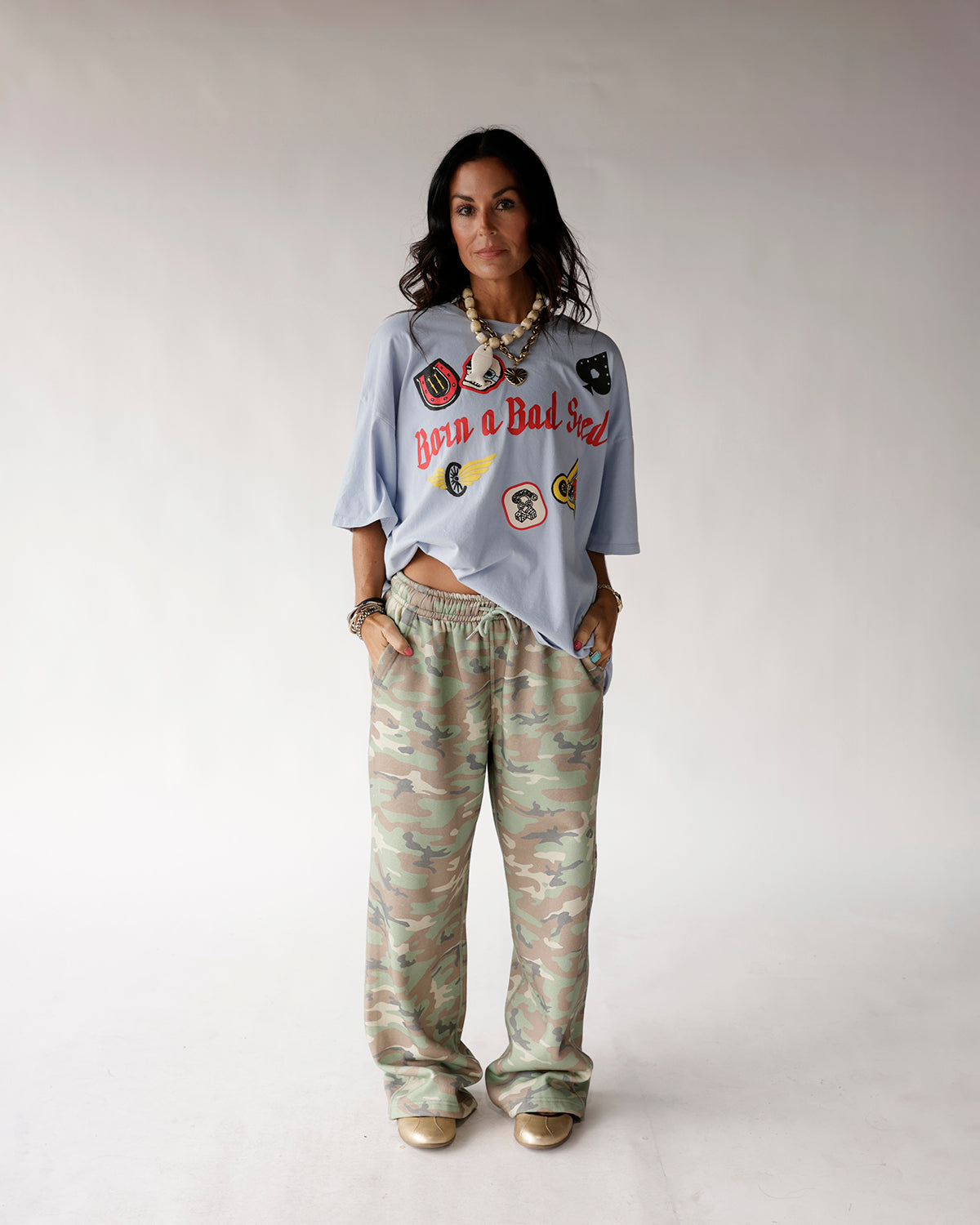 Oversized wide-leg camo sweatpants in green, tan, and brown camouflage pattern