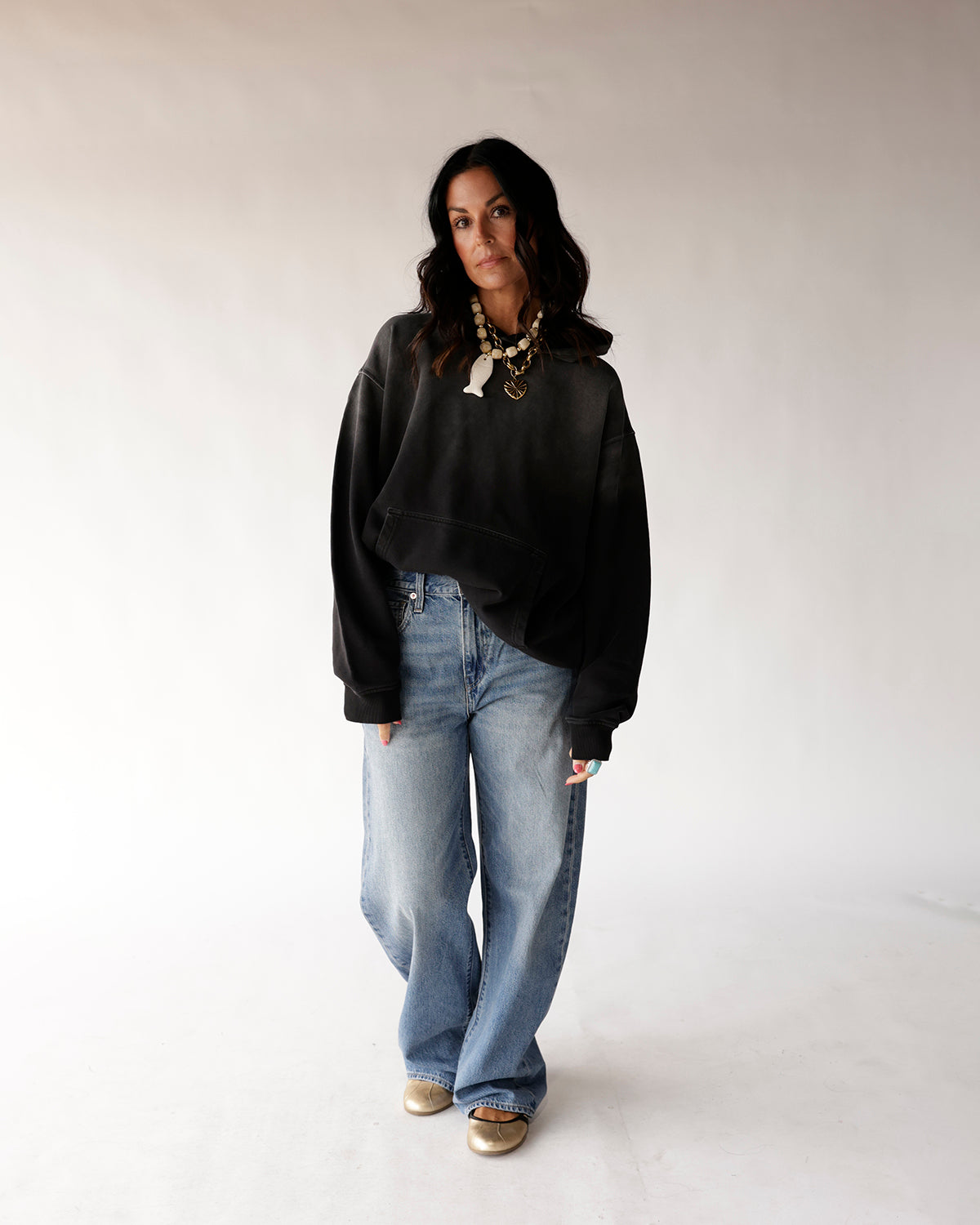 Oversized black washed crewneck sweatshirt worn with wide-leg light blue jeans