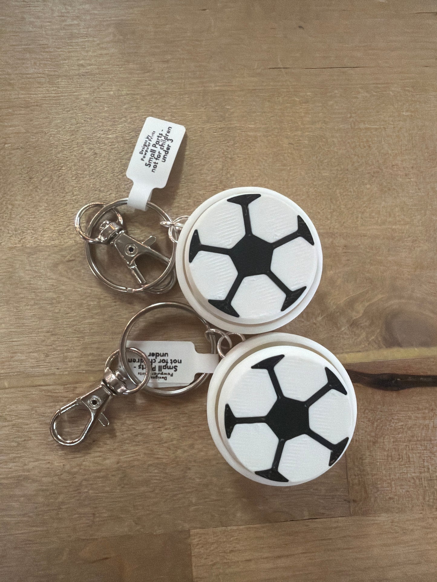 Two soccer ball design clicker keychains in black and white with silver lobster clasps