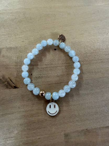 Elastic beaded bracelet with pale blue beads and gold smiley face charm