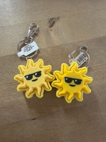 Two yellow sun with sunglasses keychains on silver lobster claw clasps