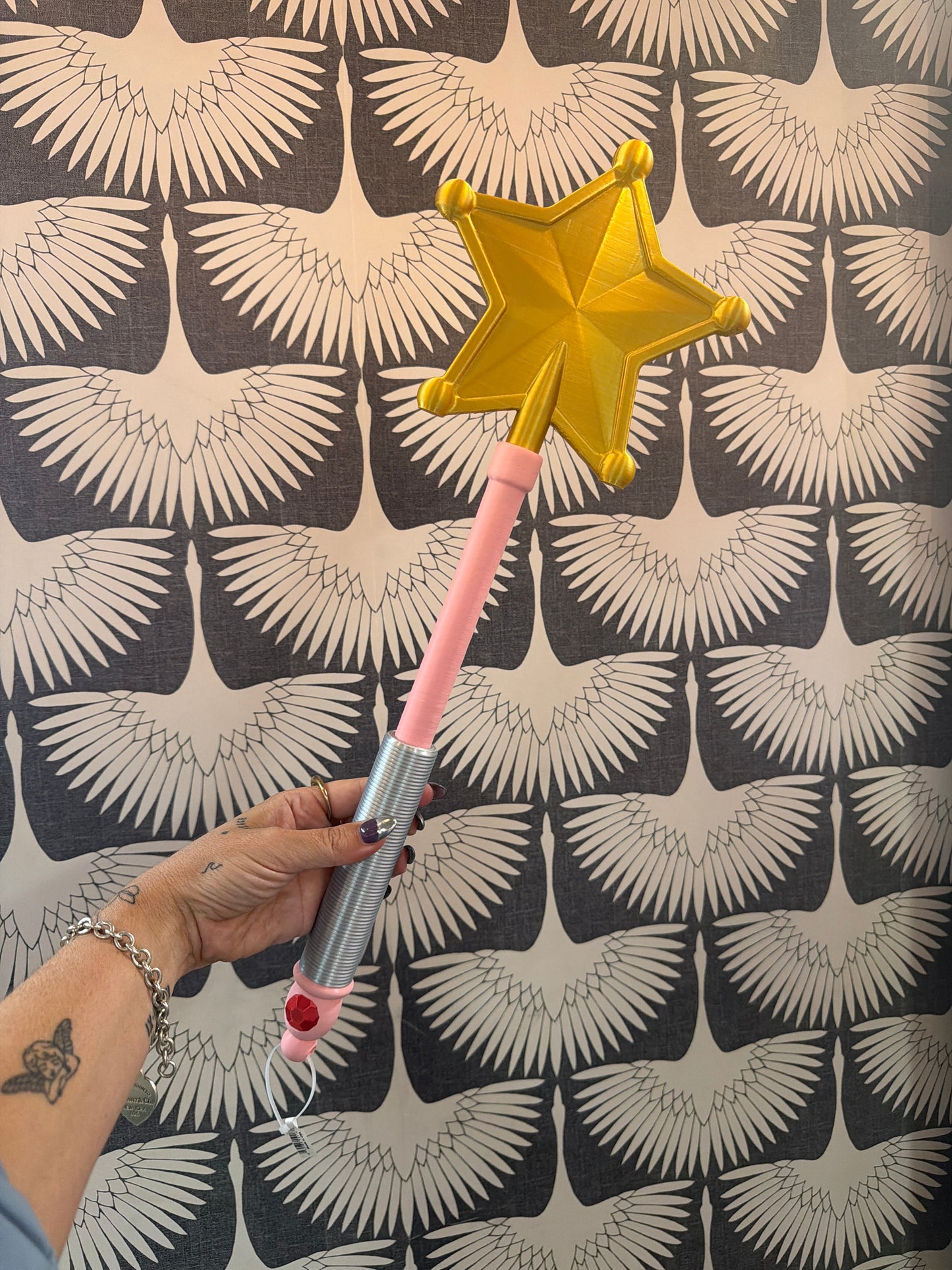 XL pink and silver magic wand with gold star top, held by hand
