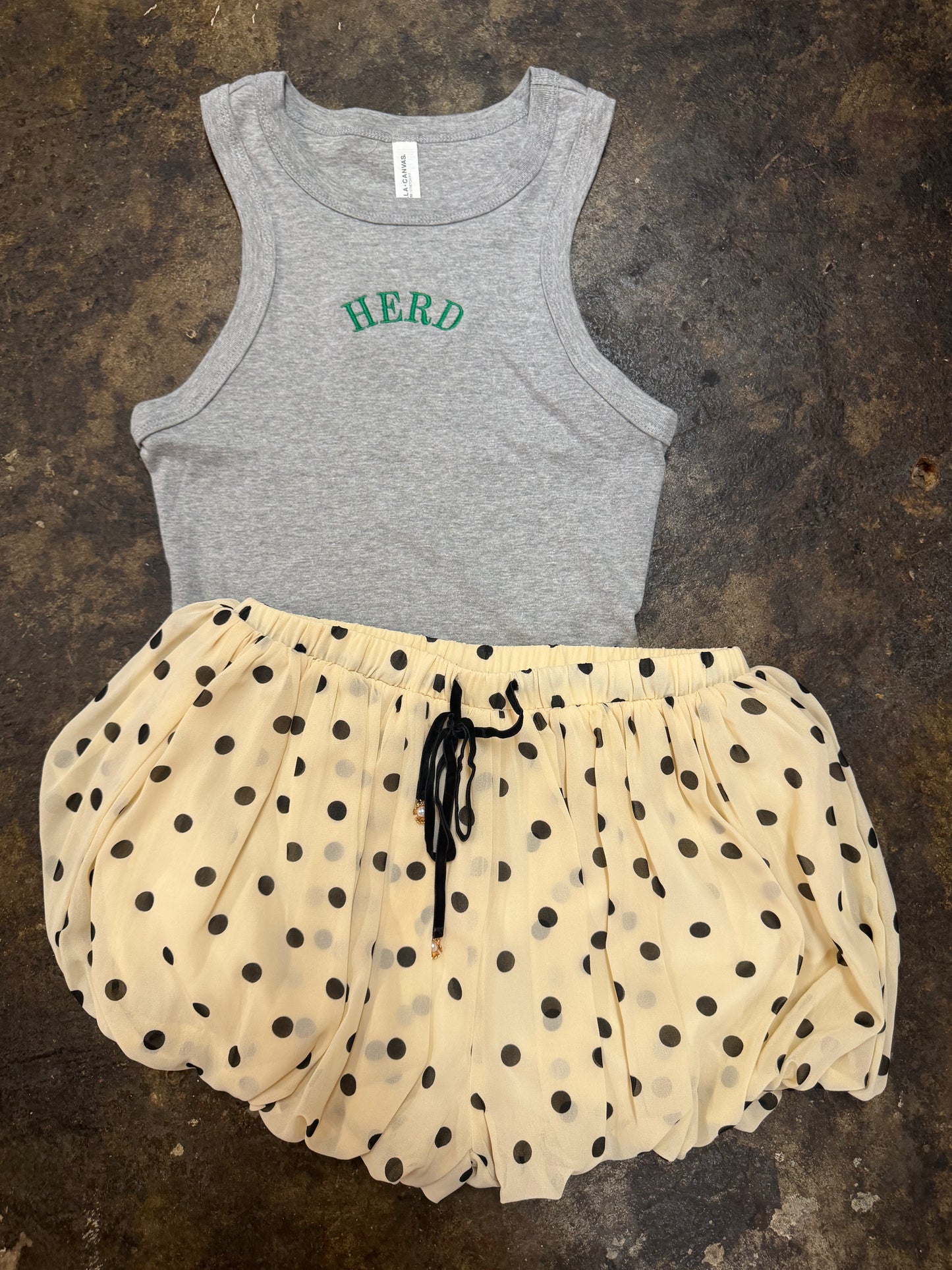 Gray racerback tank top with green HERD embroidery, styled with cream polka dot shorts