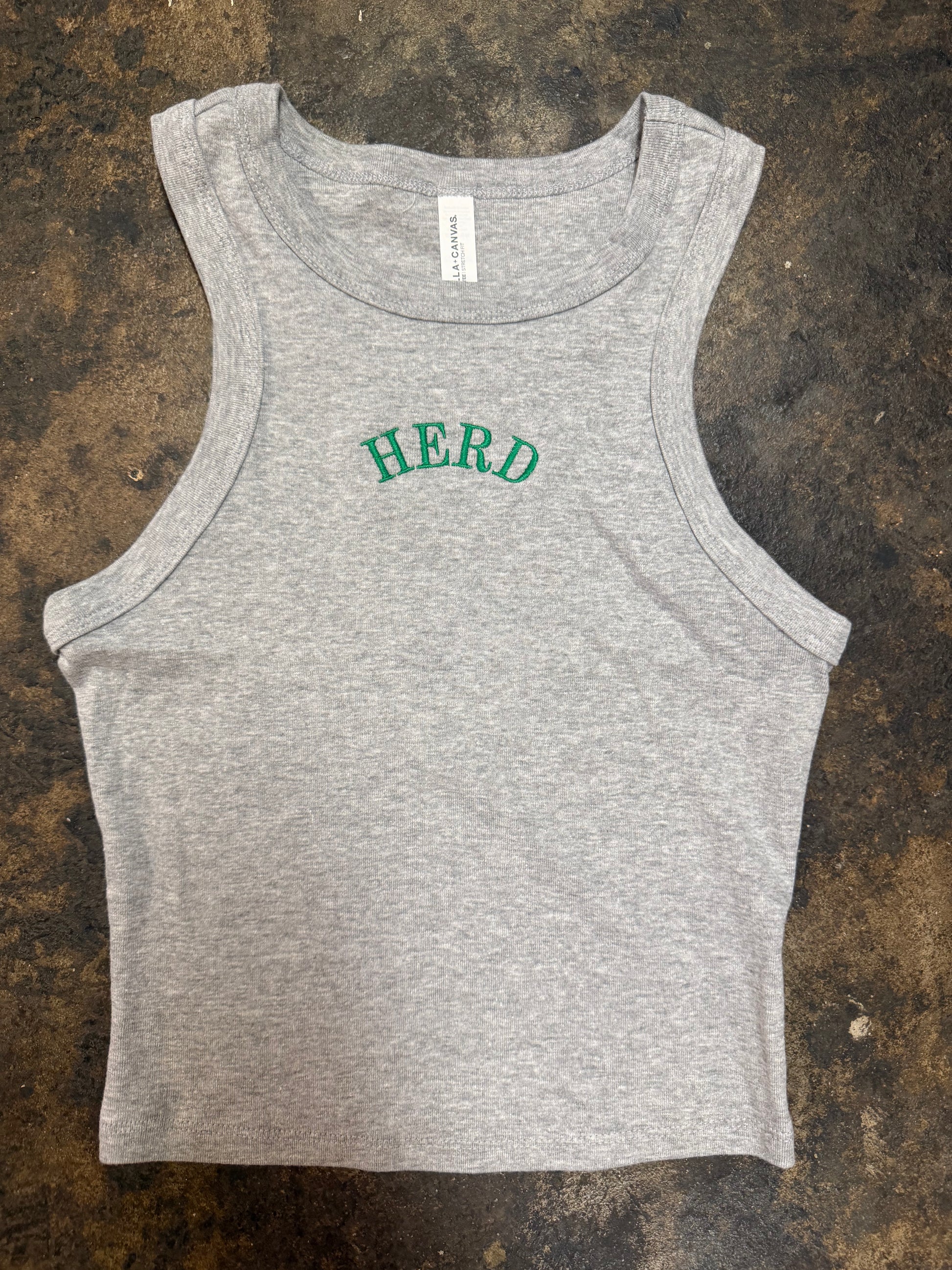 Gray racerback crop tank top with green embroidered arched HERD lettering