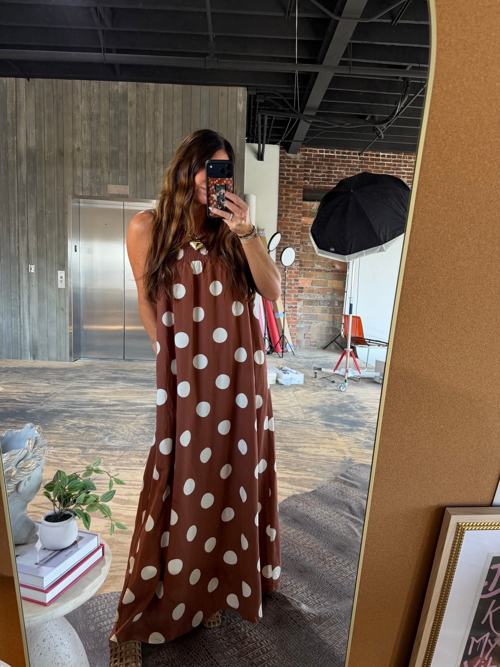 Brown polka dot sleeveless maxi dress with smocked neckline and gold hardware detail