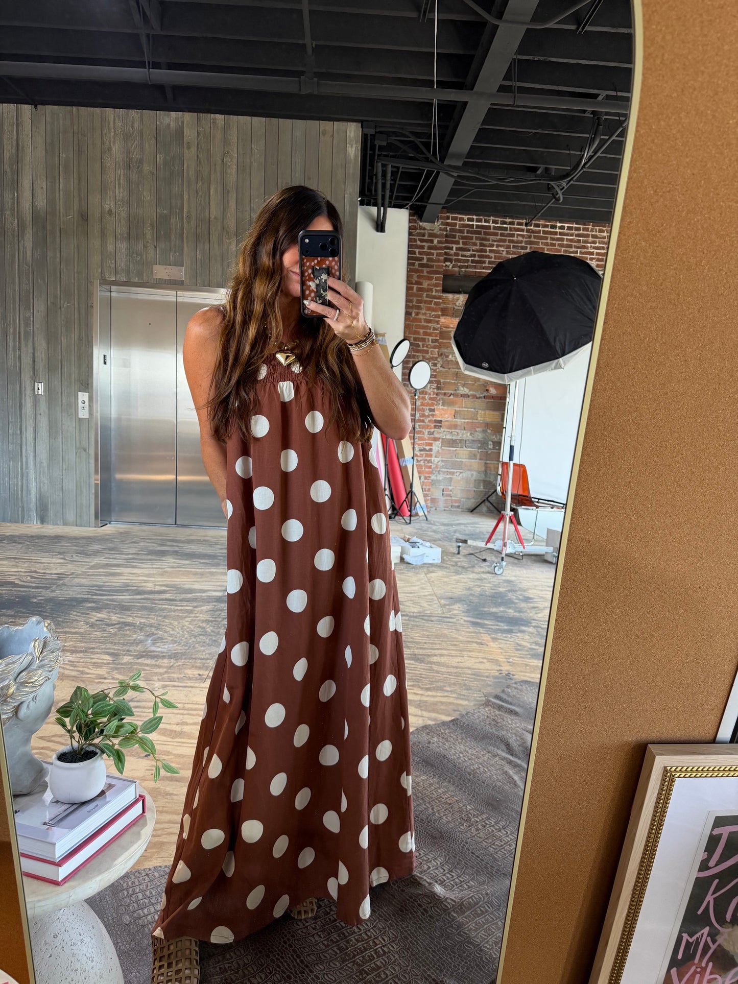 Brown polka dot sleeveless maxi dress with smocked neckline and flowy silhouette