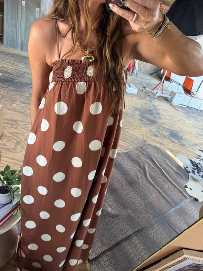 Brown maxi dress with large white polka dots, smocked bodice, and spaghetti straps