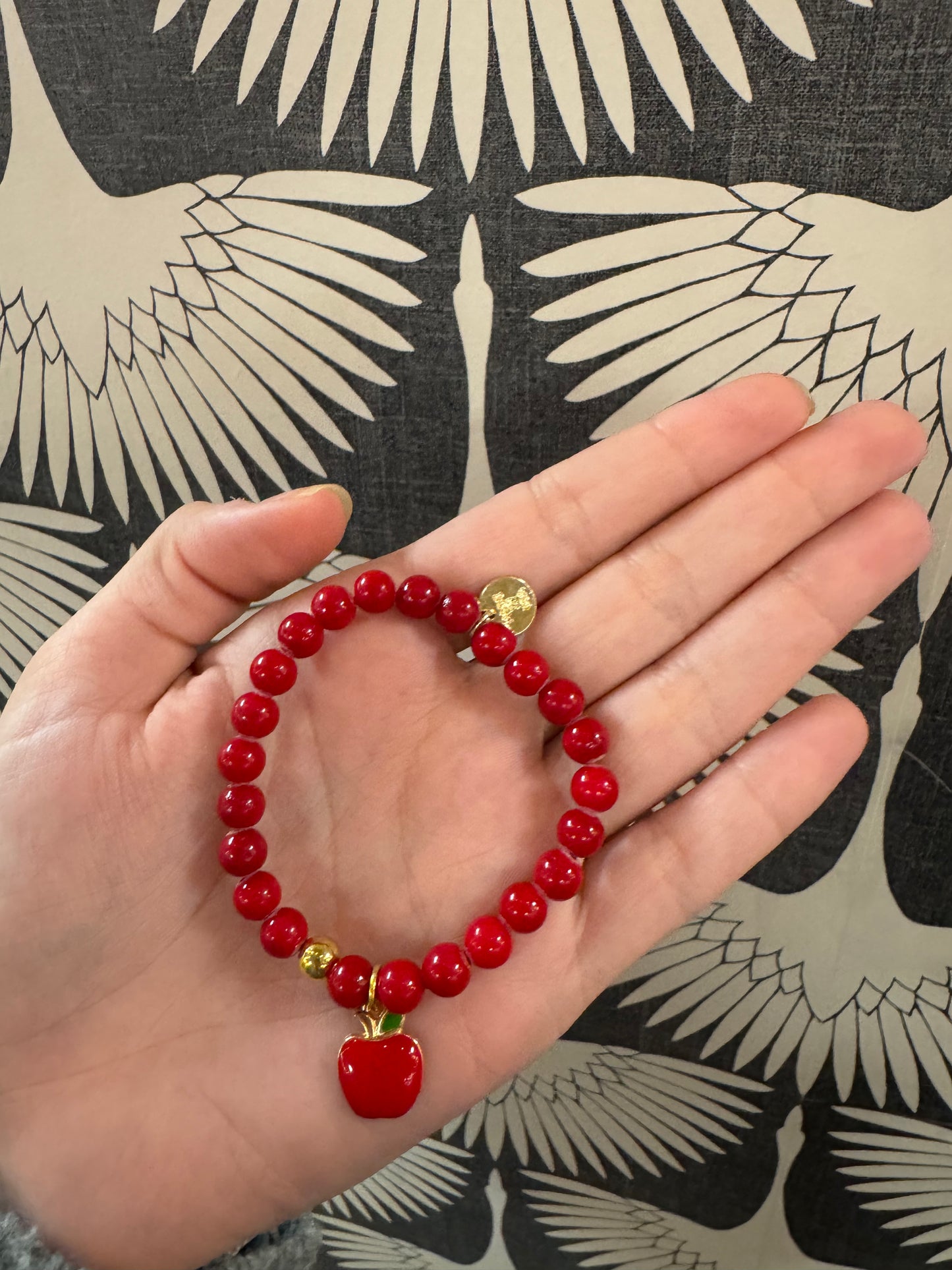 Red beaded stretch bracelet with gold coin charm and red apple pendant
