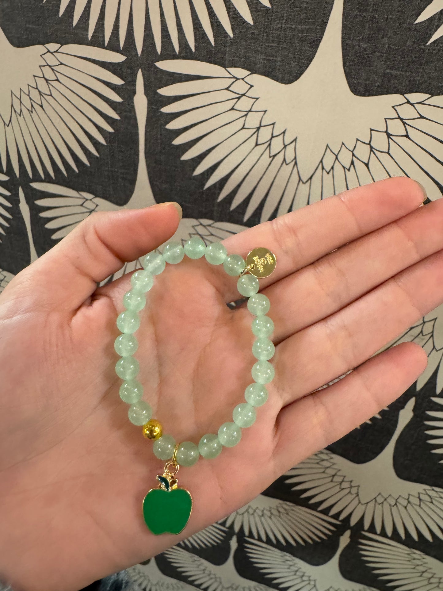 Light green beaded bracelet with green enamel apple charm and gold accent bead