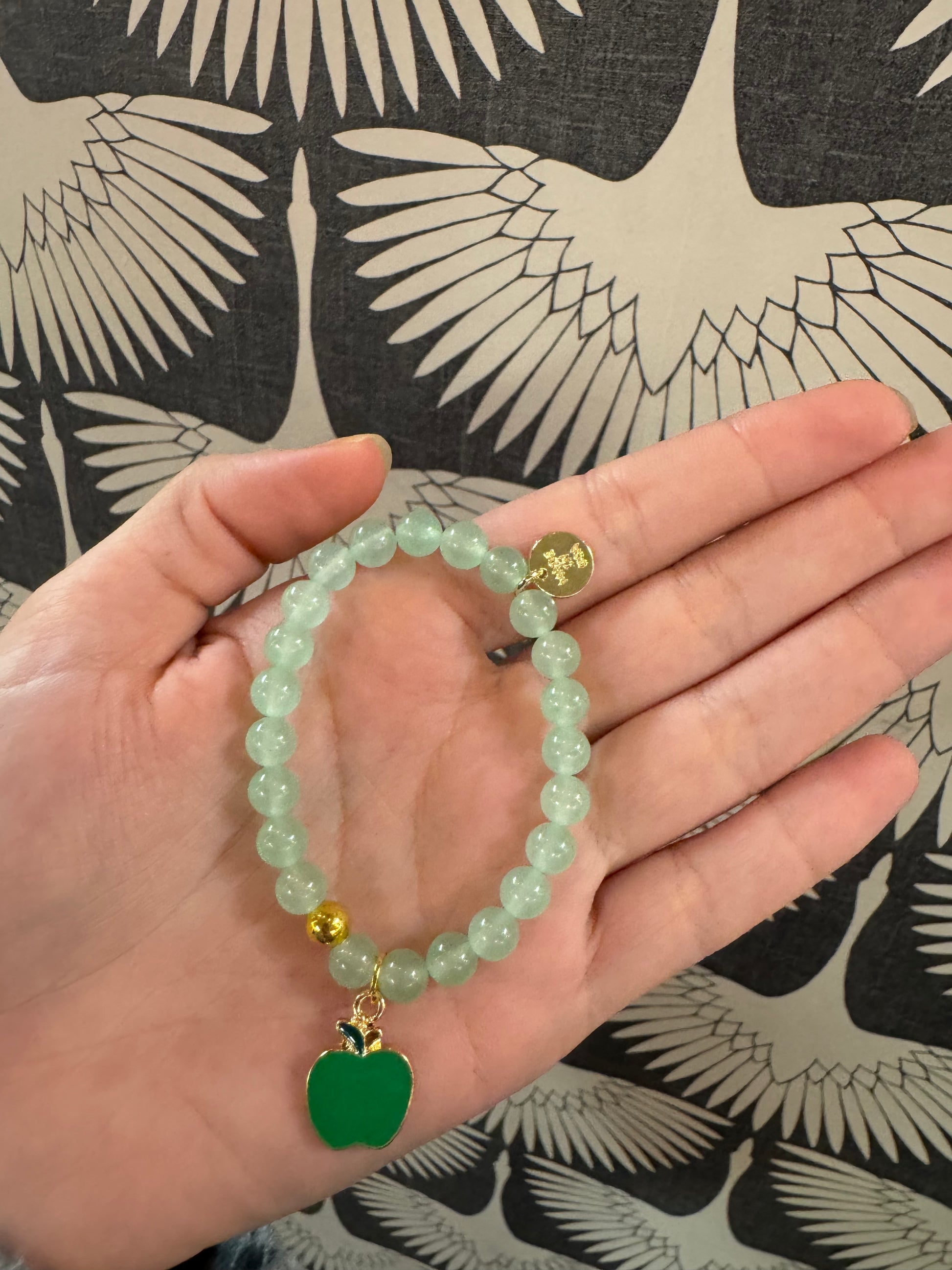 Light green beaded bracelet with green enamel apple charm and gold accent bead