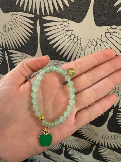 Light green beaded bracelet with green enamel apple charm and gold accent bead