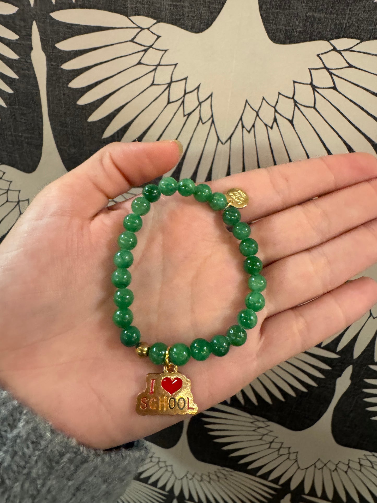 Green beaded stretch bracelet with gold and red I Love School charm