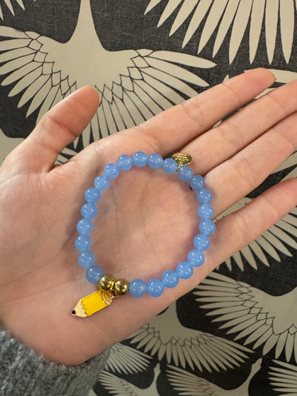 Blue beaded stretch bracelet with yellow pencil charm and gold accent beads