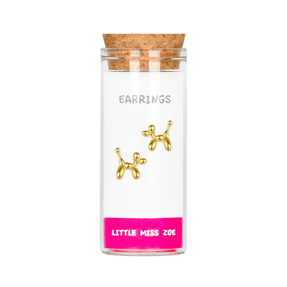 Gold balloon dog stud earrings displayed inside a small glass bottle with cork lid