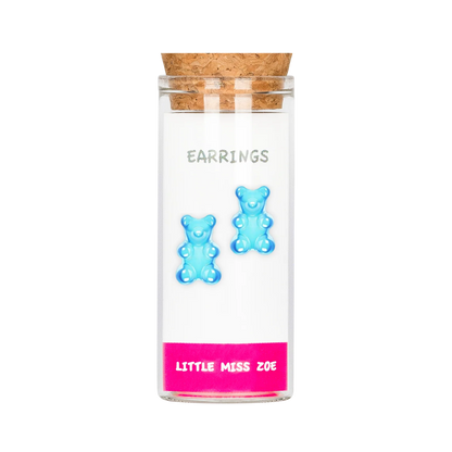 Blue gummy bear stud earrings displayed on card inside small glass bottle with cork lid