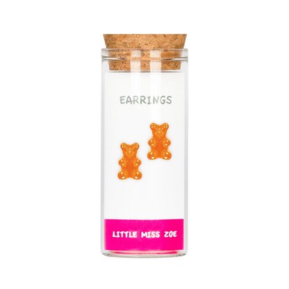 Orange gummy bear stud earrings displayed on card inside small glass bottle with cork stopper