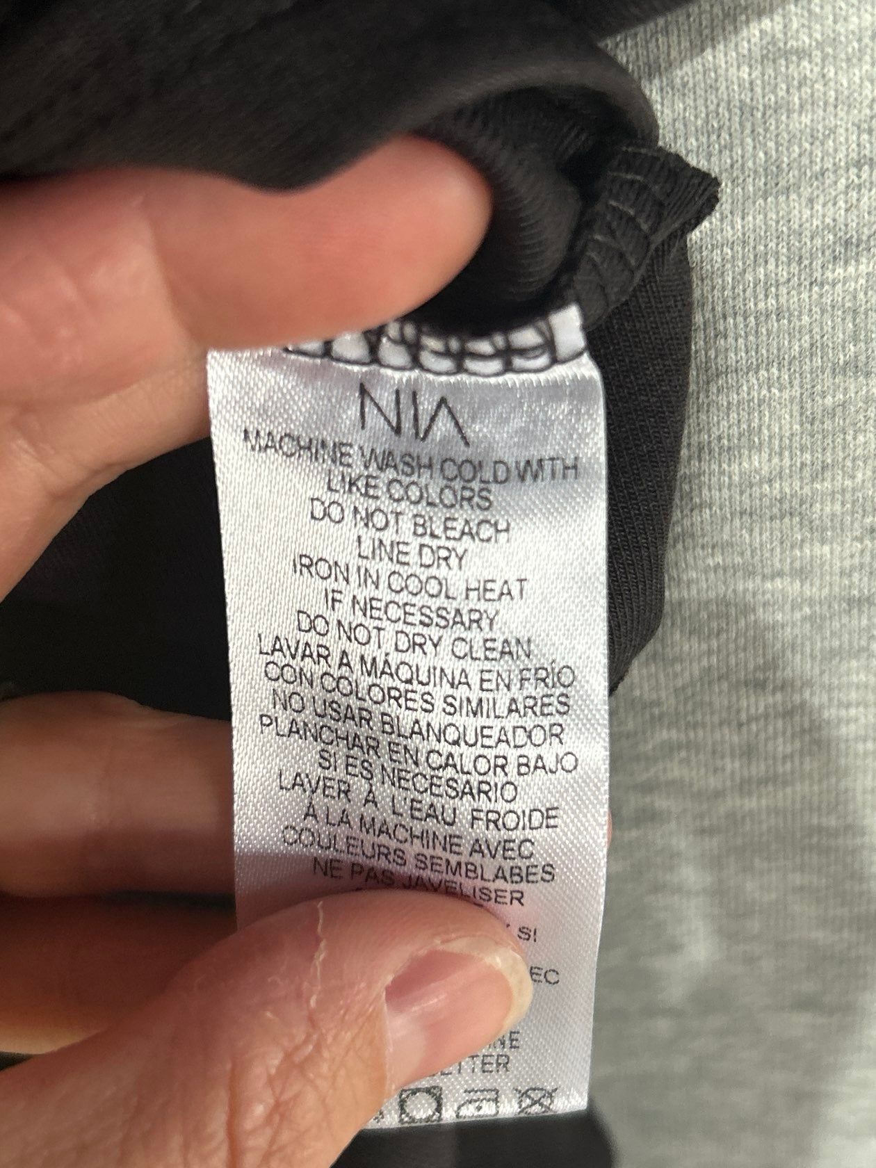 NIA brand clothing care label showing machine wash cold, line dry instructions